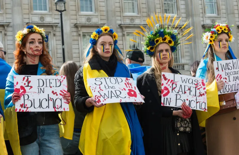 women with facepaint holding signs in protest
