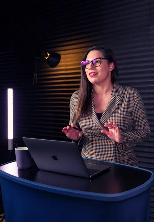 woman recording podcast in darkly lit room